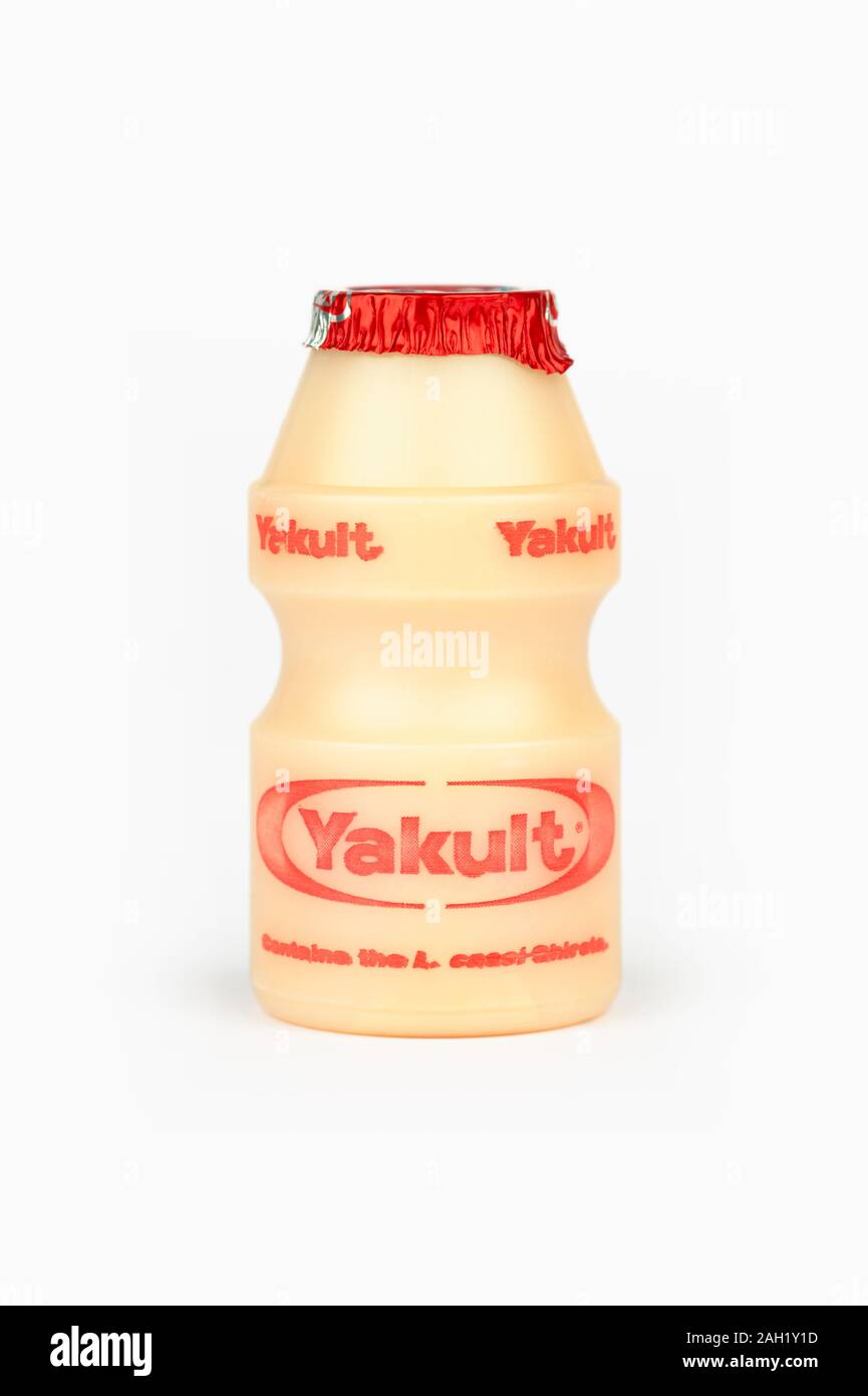A small bottle of Yakult sweetened probiotic milk beverage shot on a white background. Stock Photo