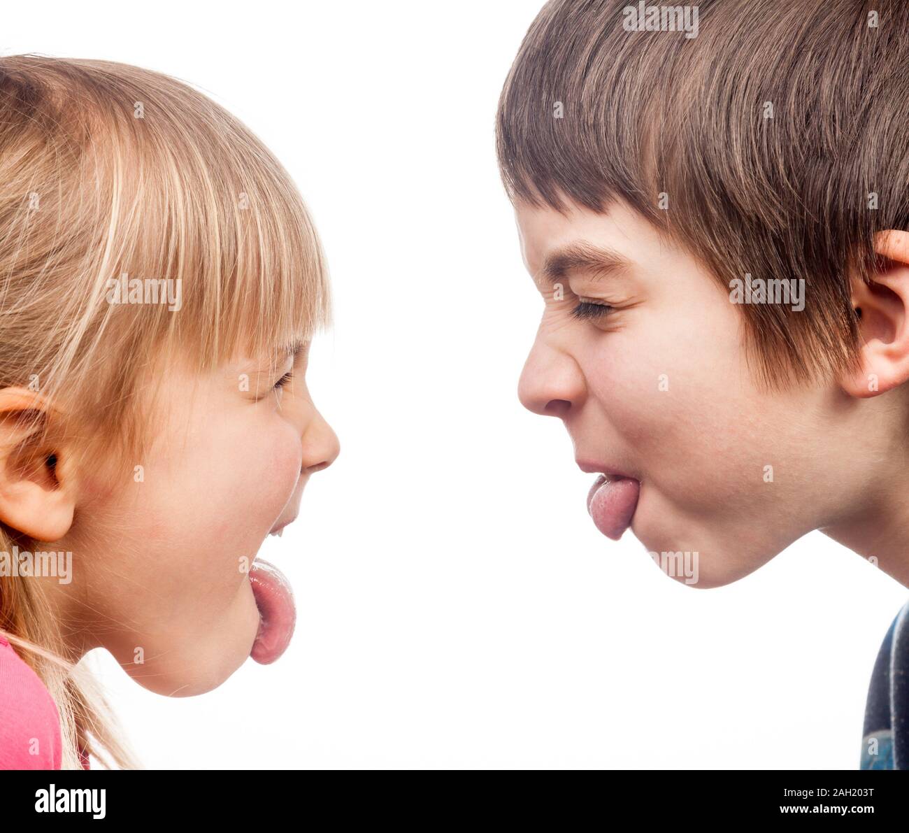 Sister and brother stick out tongues to each other Stock Photo