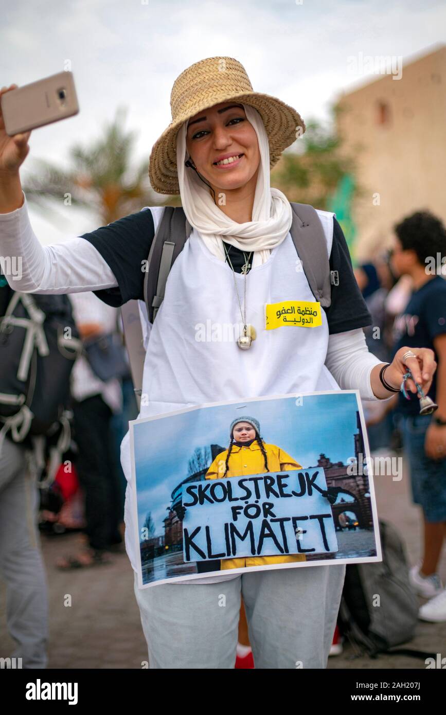 An arab woman wears a photo of Greta Thunberg Stock Photo