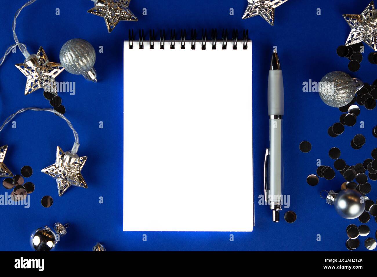 Christmas, winter composition. Notebook with isolated white page, open diary, sketch book mock-up scene on blue surface. Stock Photo