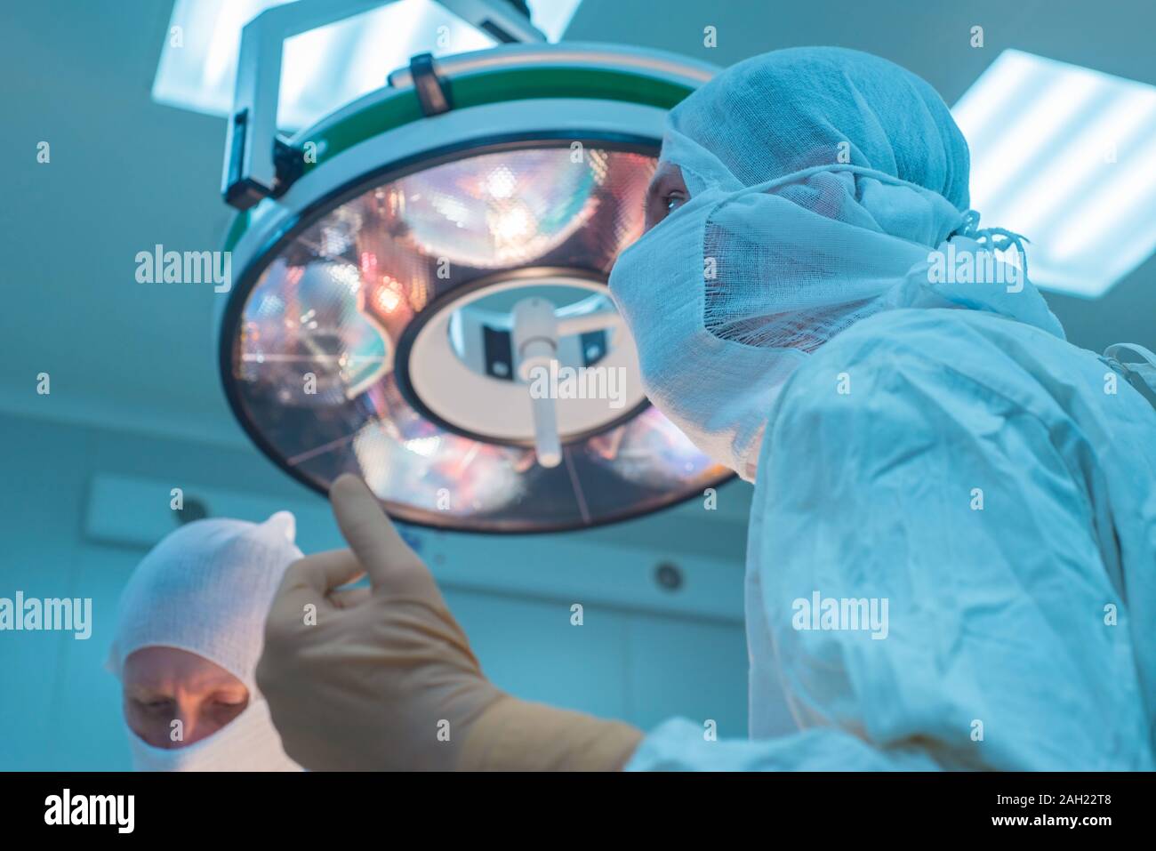 bottom view of surgeons in the operating room, in sterile masks, preparing for surgical
