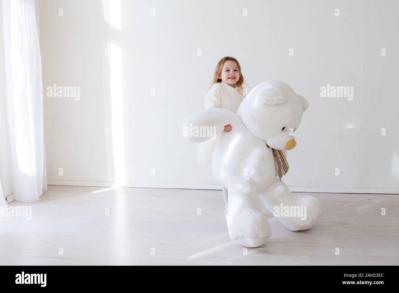 Beautiful little girl with big soft bear toy Stock Photo - Alamy