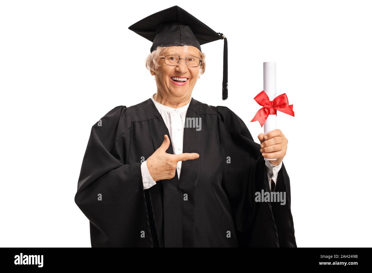 Elderly female in a graduation gown holding a diploma and pointing