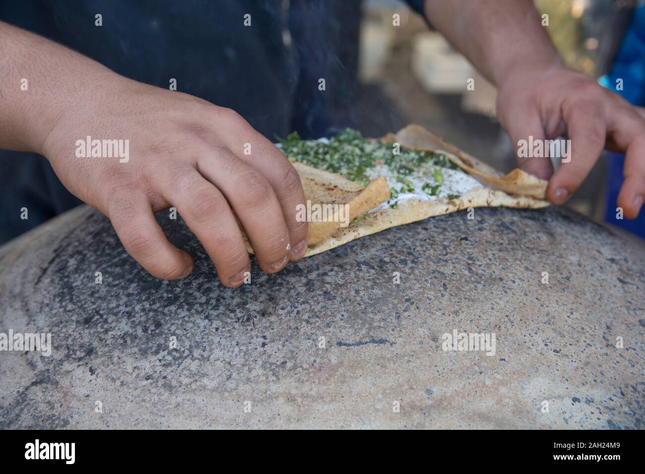 Man baking a traditional Druze Pita bread, on a Saj or Tava Stock Photo