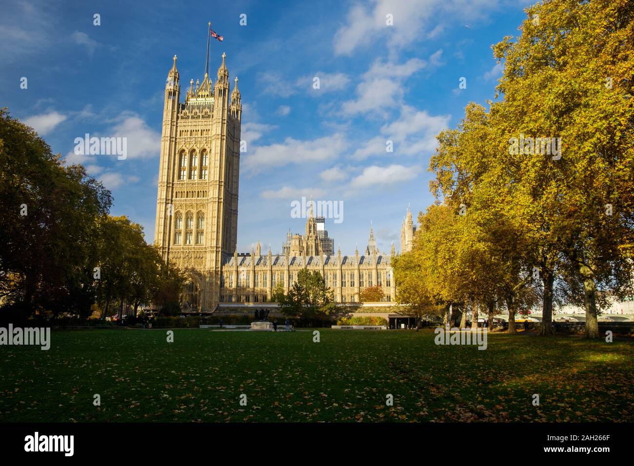 The Palace of Westminster, with Victoria Tower at the left, is one of the symbols of London. In the foreground, there are public gardens. Stock Photo