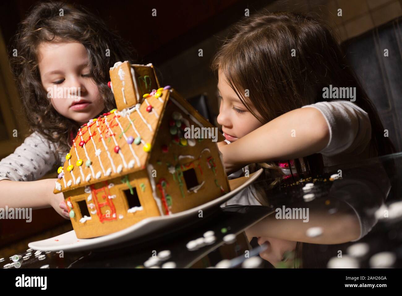Children Building Their Very First Gingerbread House Stock Photo