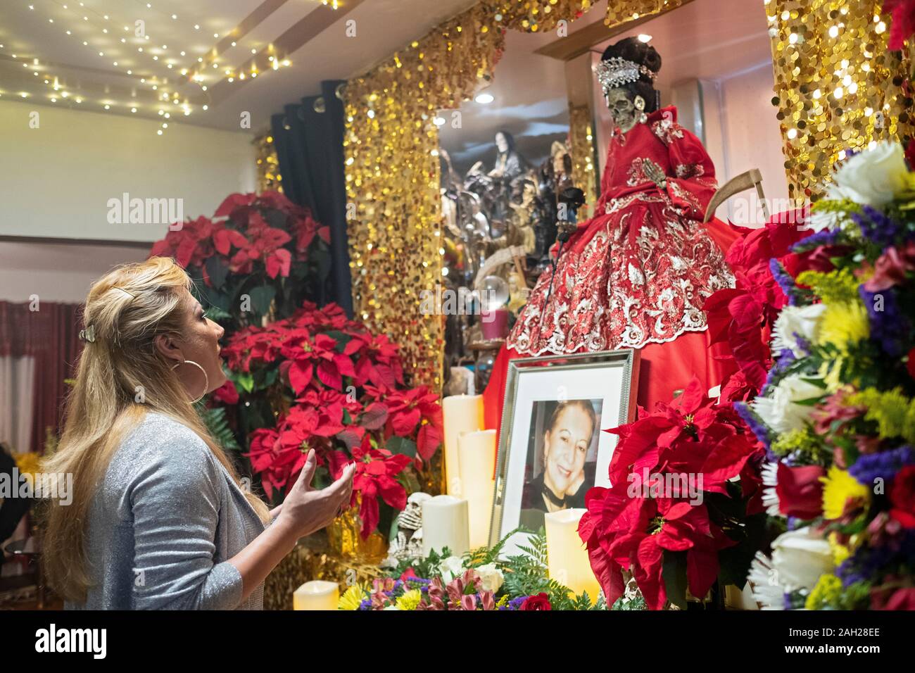 A pretty Santa Muerte priestess leads a service in a home temple in Jackson Heights, Queens, New York City. Stock Photo