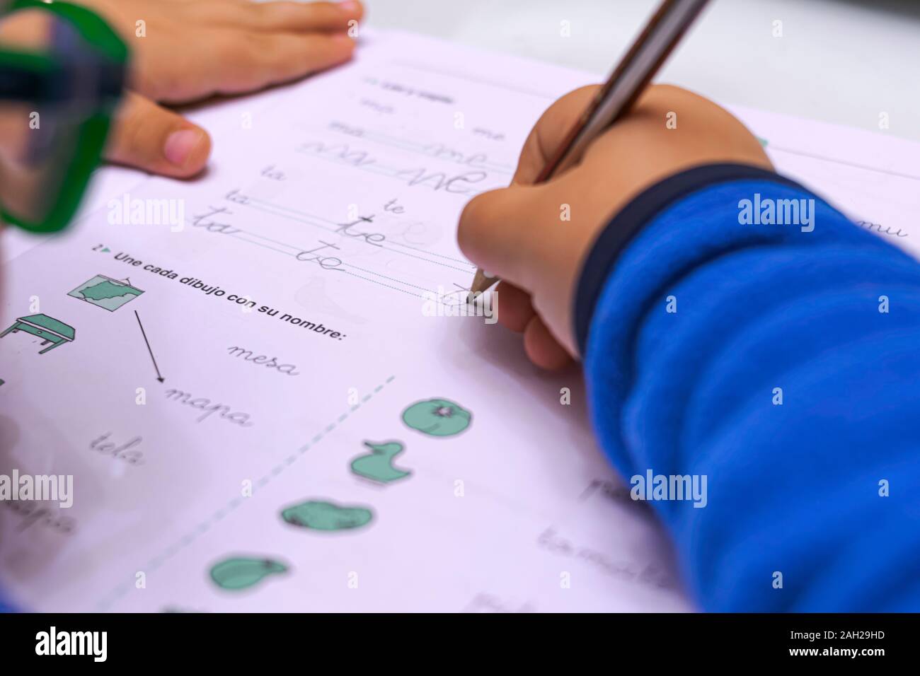 Little boy performs homework with a pencil, learning to write Stock Photo