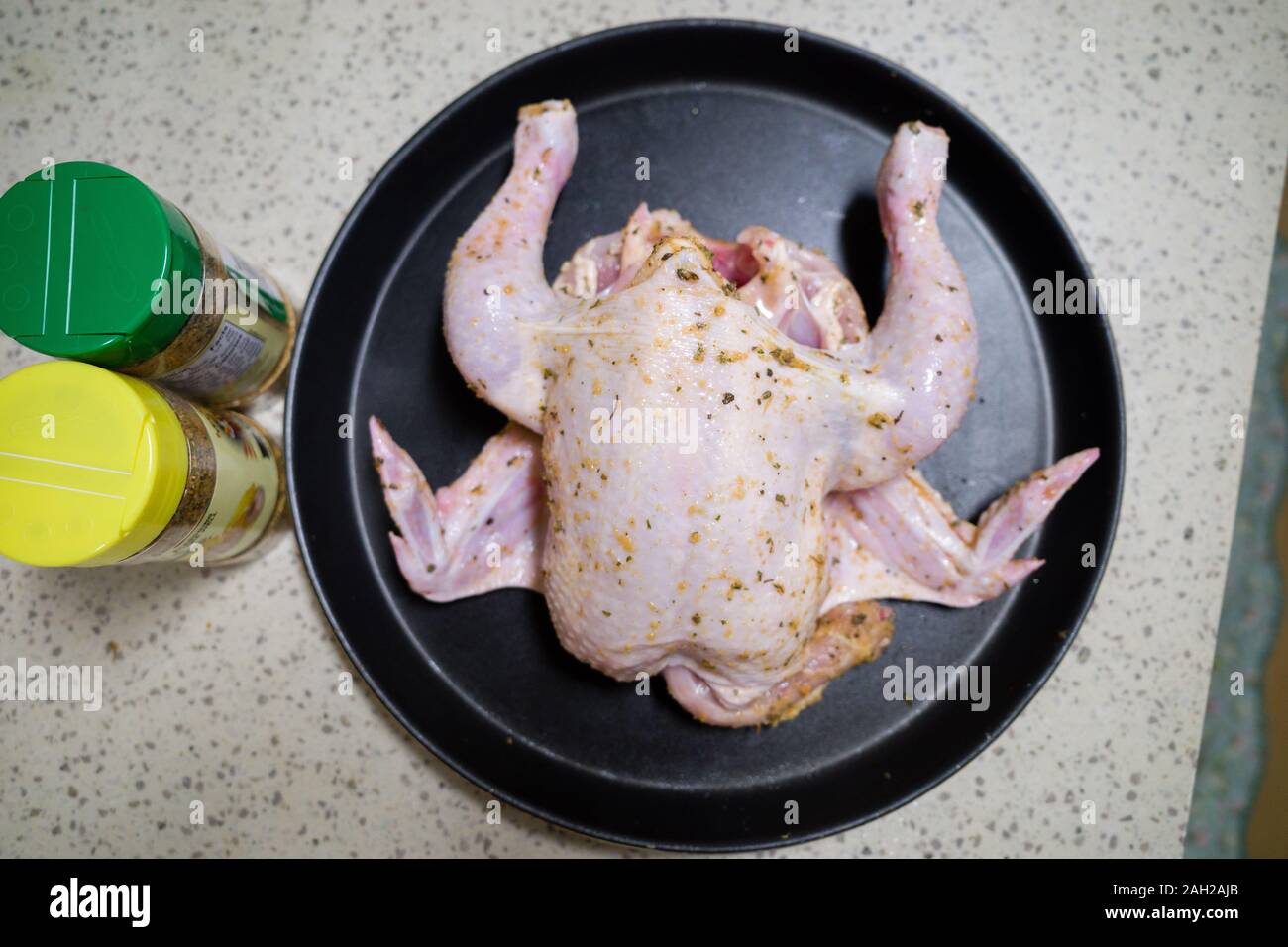 Seasoned chicken is placed on a tray before baking. Stock Photo