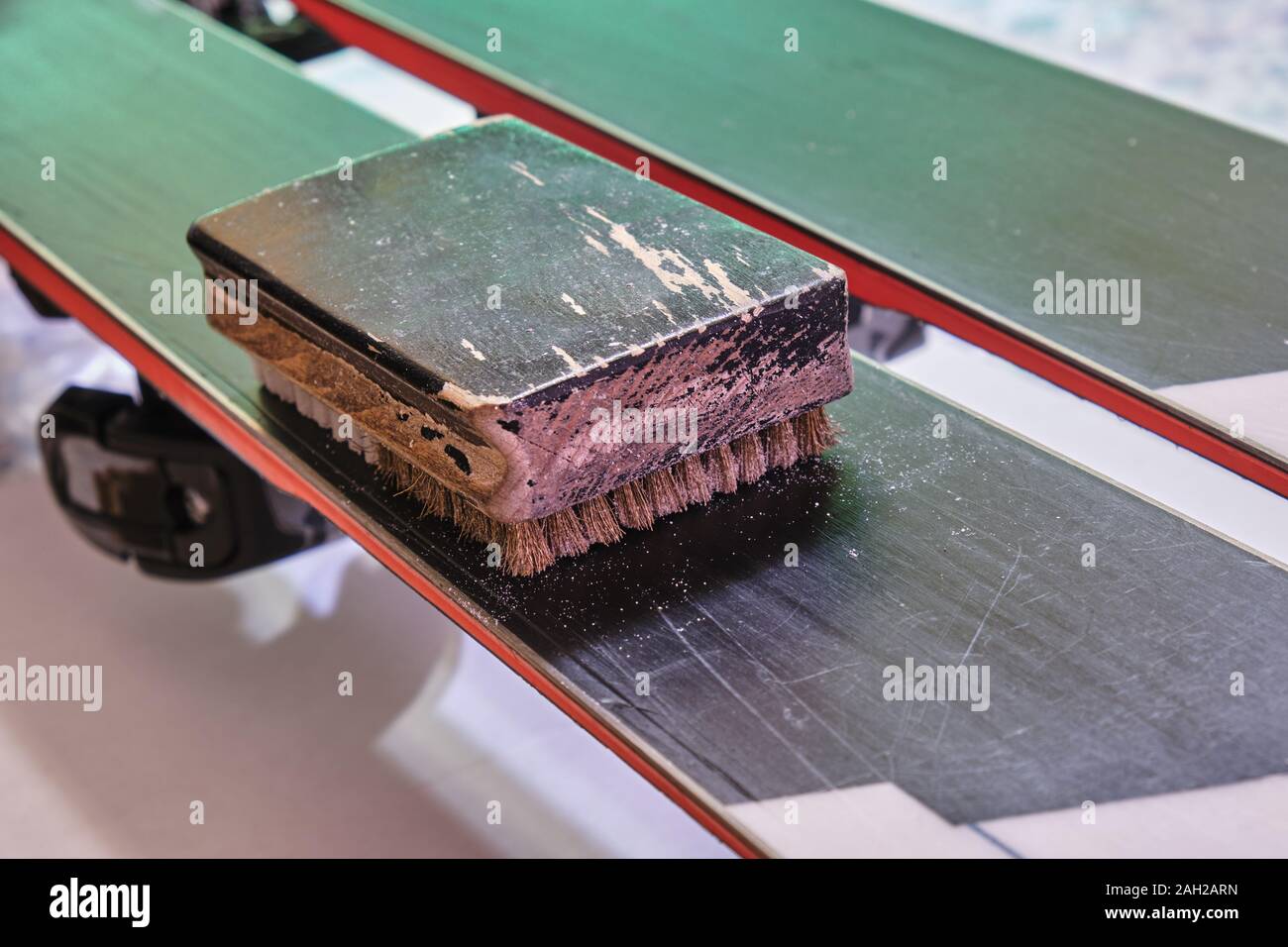 Brass/Nylon brush tool, on top of a ski base. This ski tuning and