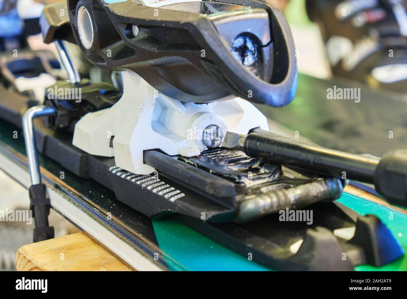Screw for adjusting forward pressure in a ski binding using a screwdriver,  after clipping the ski boot in first Stock Photo - Alamy