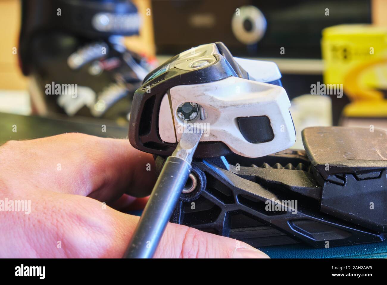 Adjusting DIN value (release setting) of a ski binding front (toe) piece  using a flathead screwdriver - side view Stock Photo - Alamy