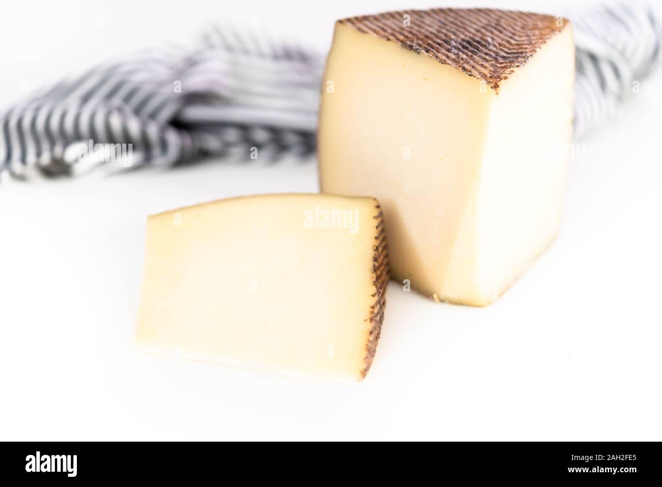 Large slice of aged Manchego cheese on a white background Stock Photo ...
