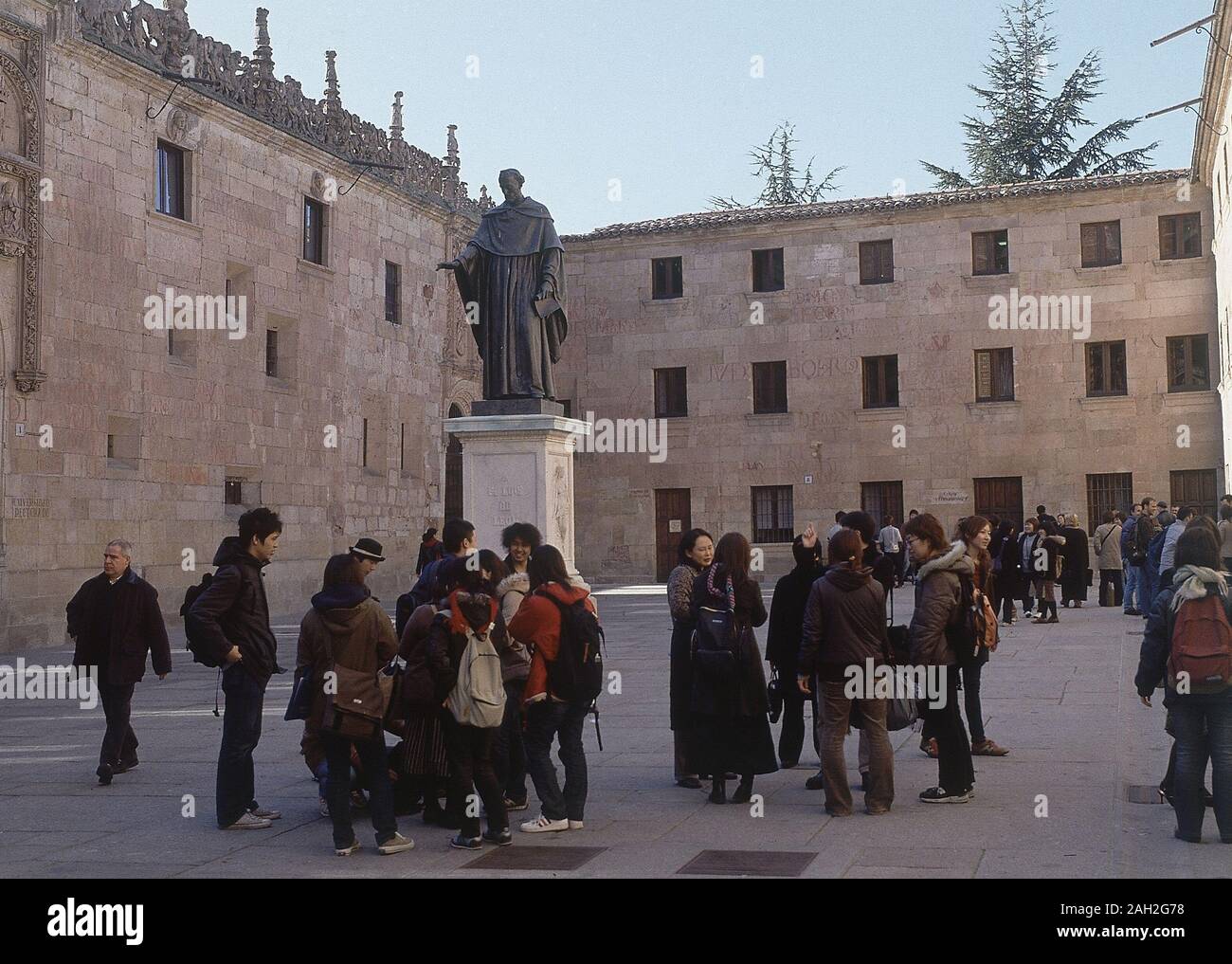 ESTATUA DE FRAY LUIS DE LEON EN EL PATIO DE LAS ESCUELAS MAYORES RODEADA DE TURISTAS JAPONESES. Author: SEVILLA NICASIO. Location: UNIVERSIDAD. SALAMANCA. SPAIN. Stock Photo