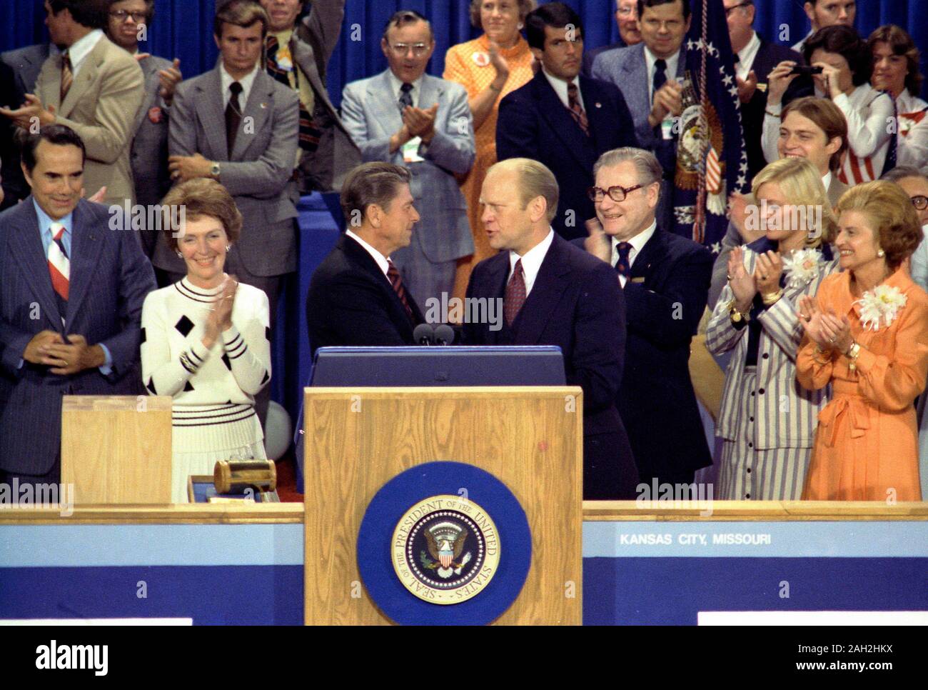 President Gerald Ford, as the Republican nominee, shakes hands with nomination foe Ronald Reagan on the closing night of the 1976 Republican National Convention. Vice-Presidential Candidate Bob Dole is on the far left, then Nancy Reagan, Governor Ronald Reagan is at the center shaking hands with President Gerald Ford, Vice-President Nelson Rockefeller is just to the right of Ford, followed by Susan Ford and First Lady Betty Ford. August 19, 1976 Stock Photo