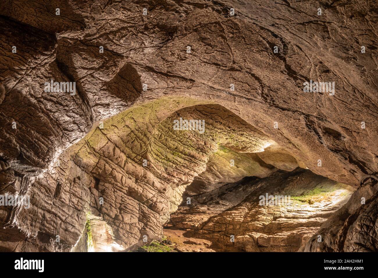 View inside the ancient cave with stone walls with additional lighting. Texture of a stone wall
