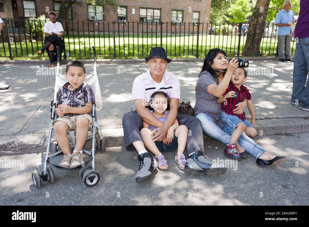 Ecuadorian-American family watches The Children's Evangelical Parade in East Harlem in NYC. Stock Photo