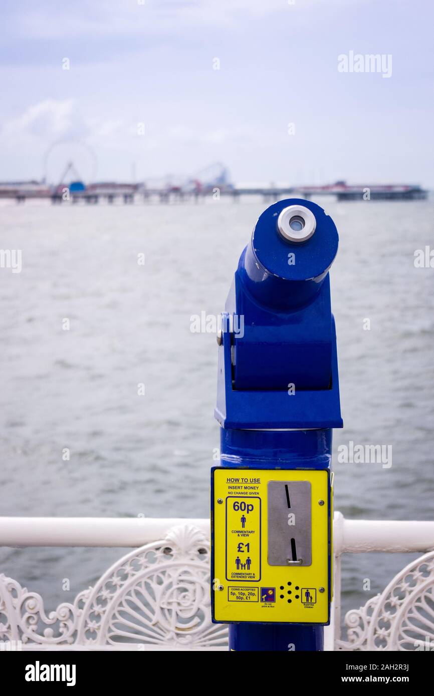 coin operated telescope on pier looking out across the sea to a pier Stock Photo