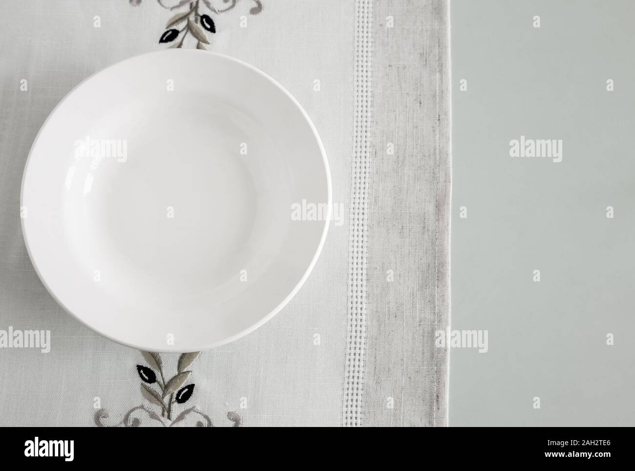 A white empty plate on a linen napkin Stock Photo