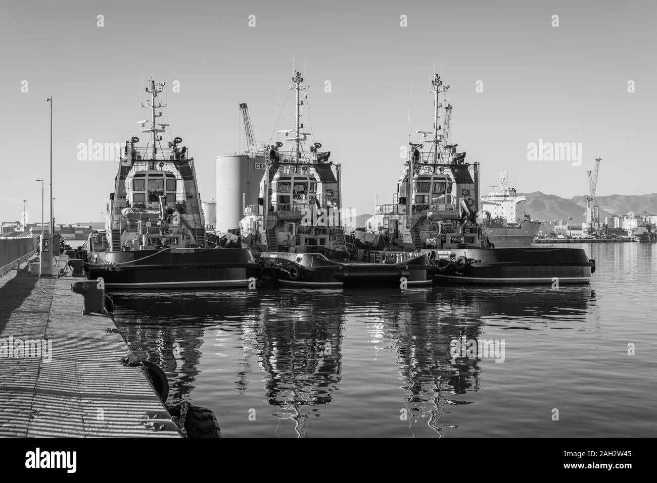 Malaga, Spain - December 4, 2018: Sea tugboats moored in the port of Malaga, Andalusia, Spain. Black and white photography. Stock Photo