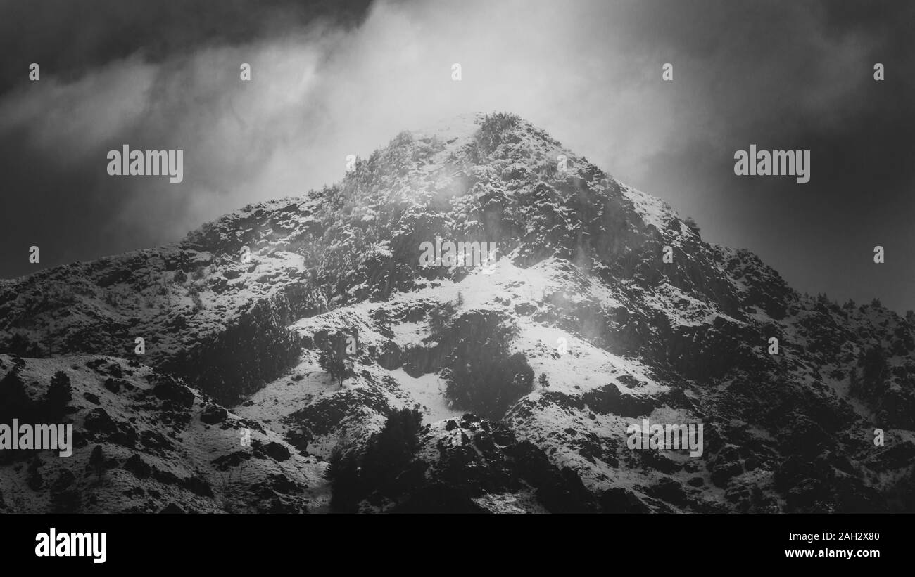 Amazing light passing through clouds and falling on the snow clad Zabarwan Mountain Range in Srinagar Stock Photo