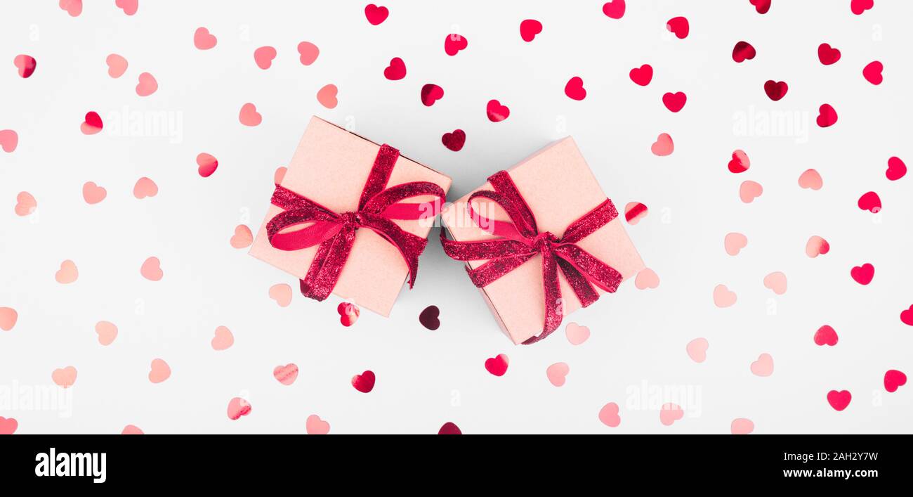Craft box with red ribbon bow and glitter heart confetti. Valentine day ...