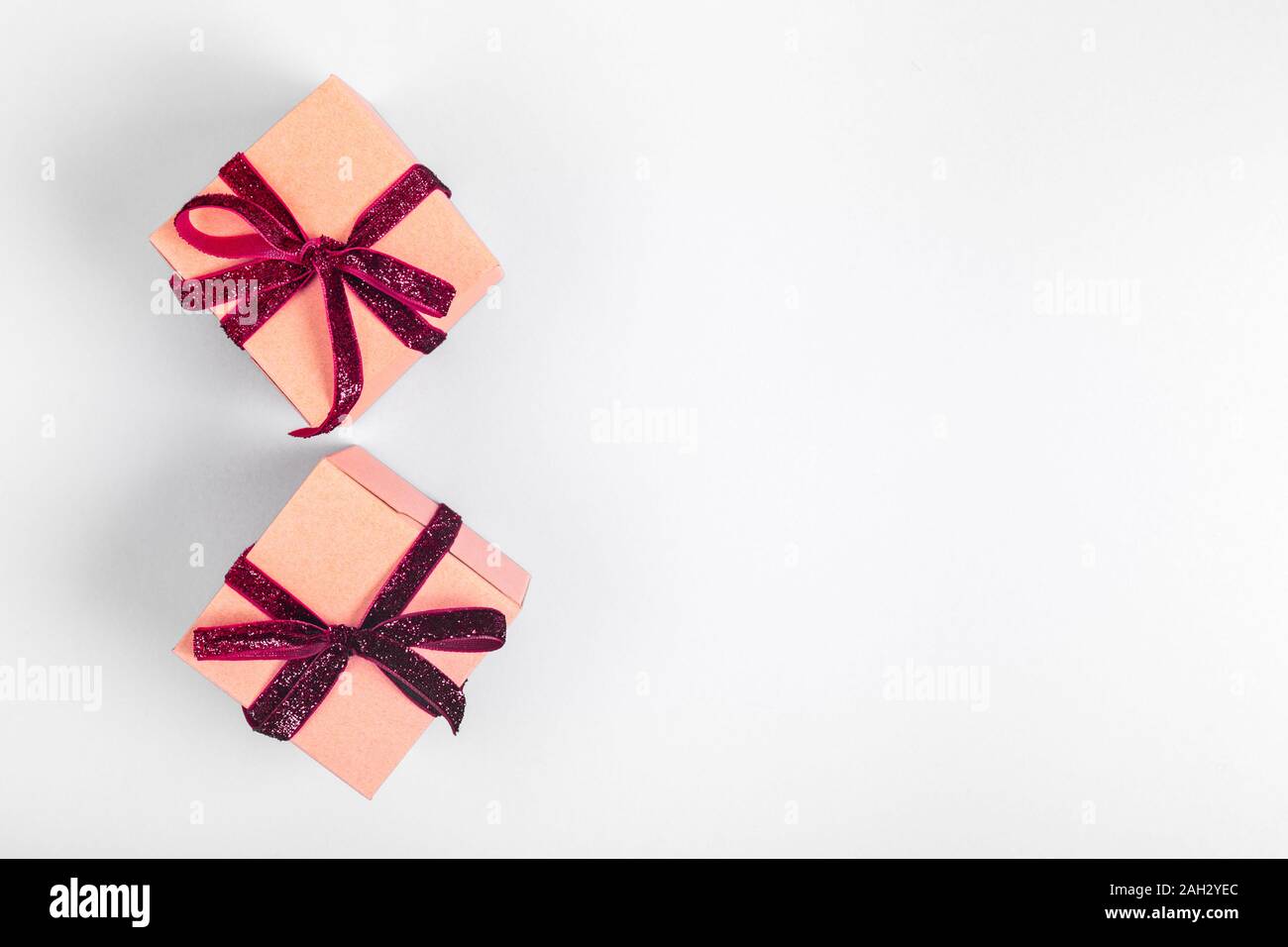 Craft boxes with dark red ribbon bows. Holiday, Christmas, New Year and  Valentine day eco-friendly wrapping concept. Trendy minimalistic flat lay  design background. Horizontal Stock Photo - Alamy