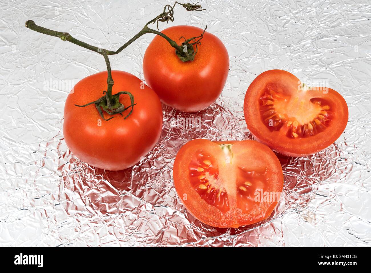 Some tomatoes on aluminum foil Stock Photo Alamy