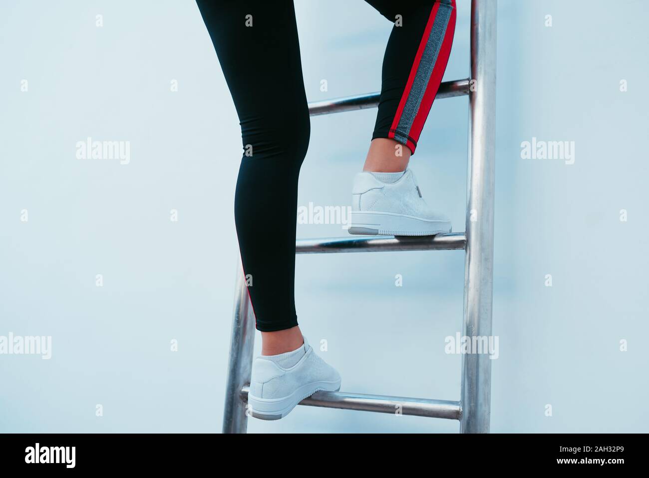 Sporty woman climbing the ladder Stock Photo Alamy