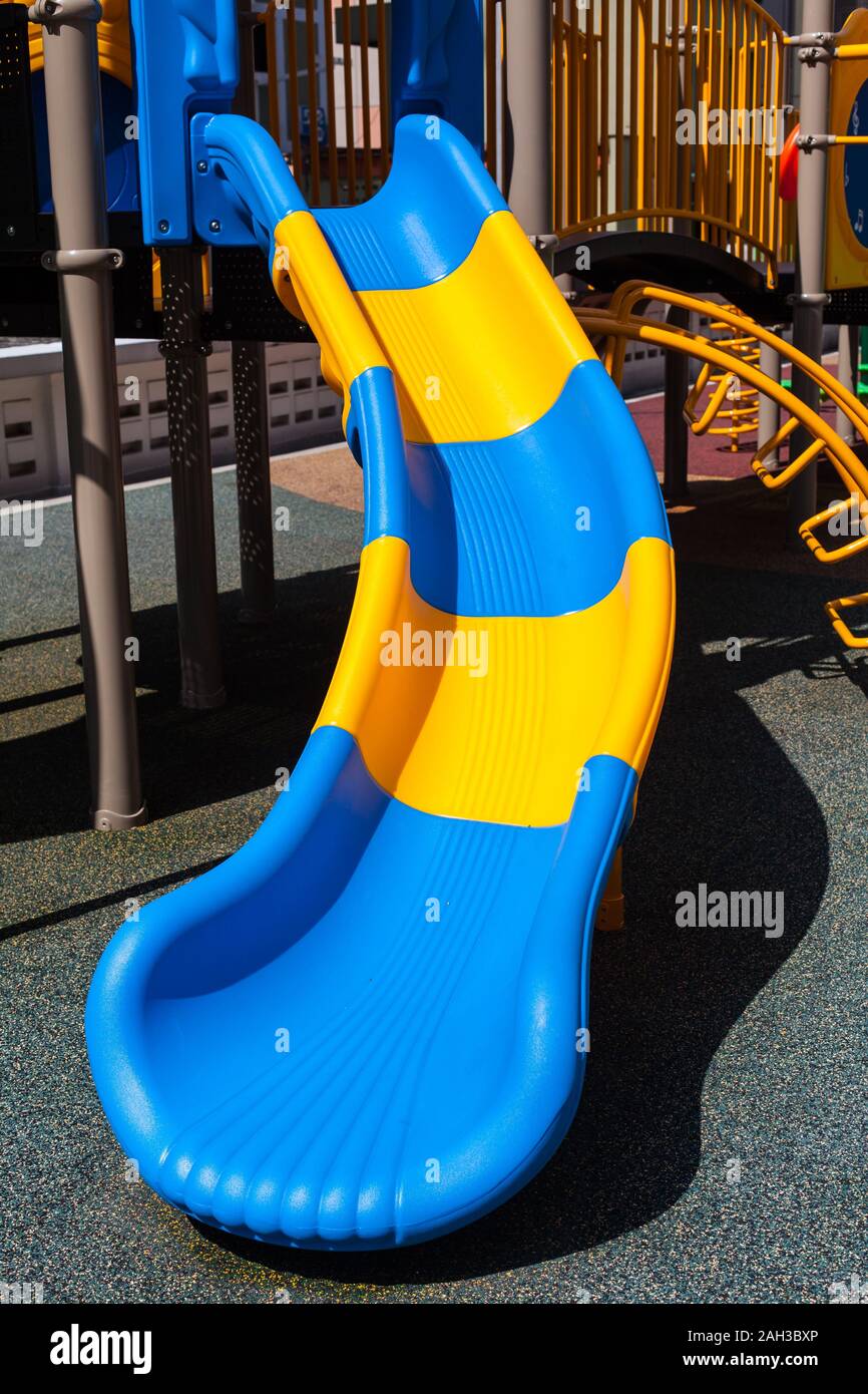 Close up vertical picture of children playground yellow and blue colours slide design at sunny
