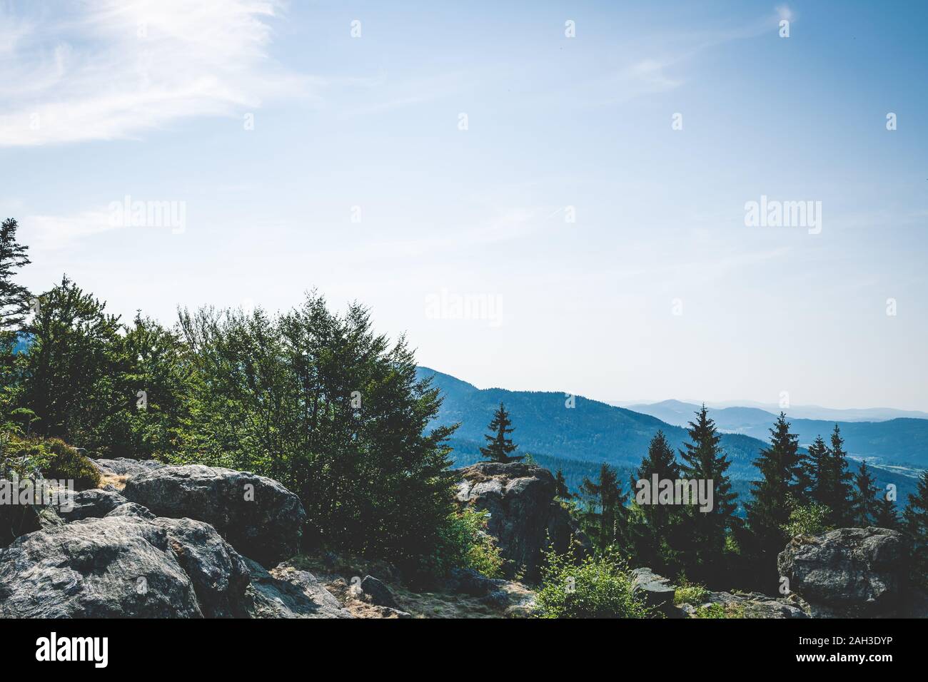 View from the top of a mountain into the valley with clouds in the blue ...
