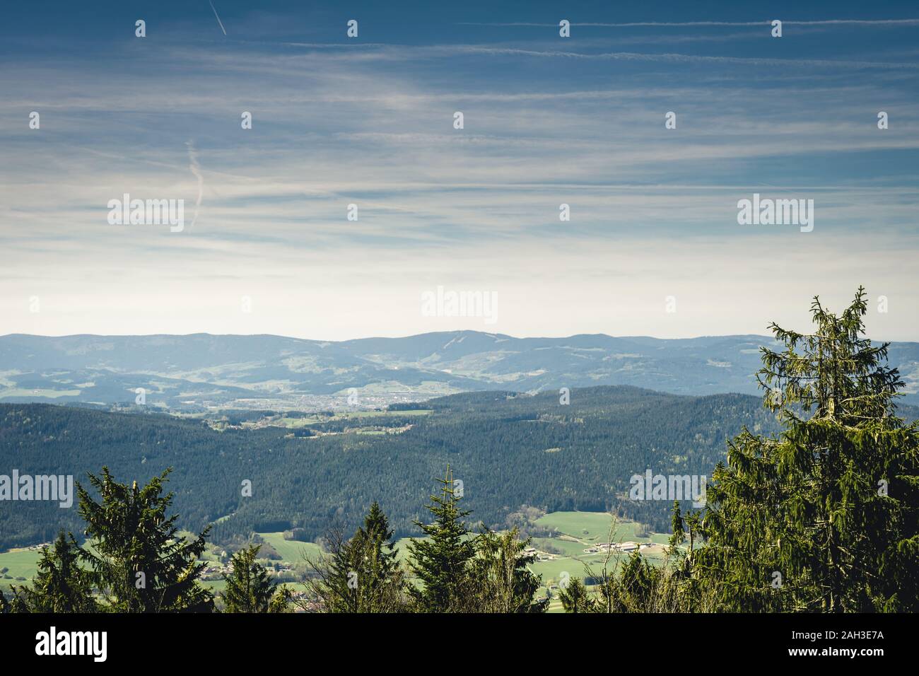 View from the top of a mountain into the valley with clouds in the blue ...