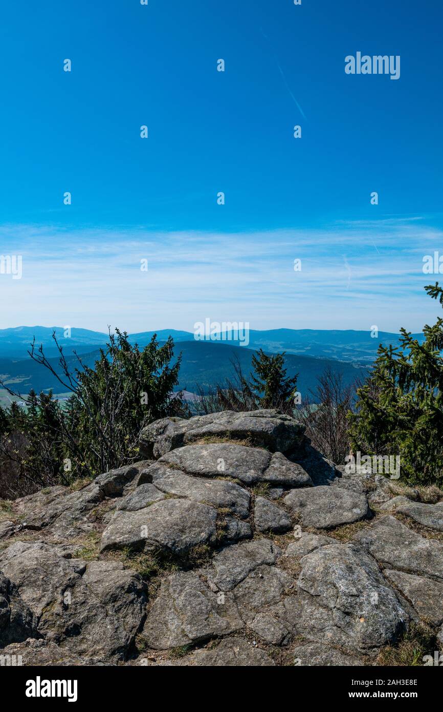View from the top of a mountain into the valley with clouds in the blue ...