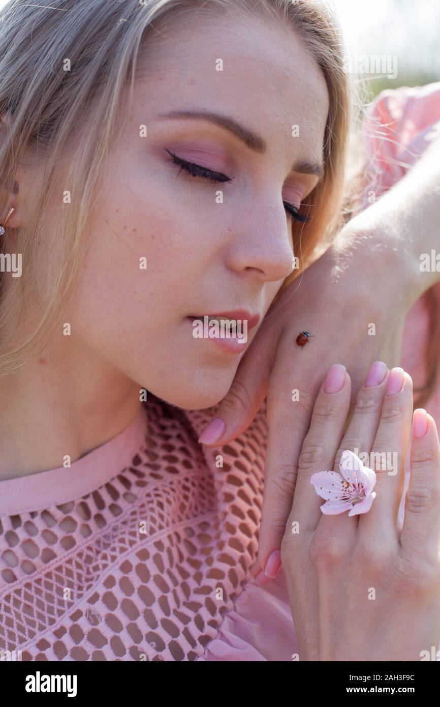 insect ladybug on a blonde woman's arm Stock Photo