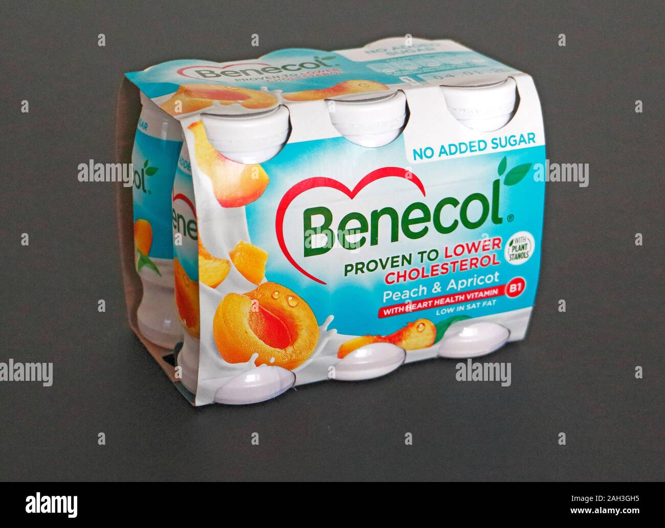 A carton of peach and apricot flavoured Benecol yogurt drinks proven to lower cholesterol against a black background. Stock Photo