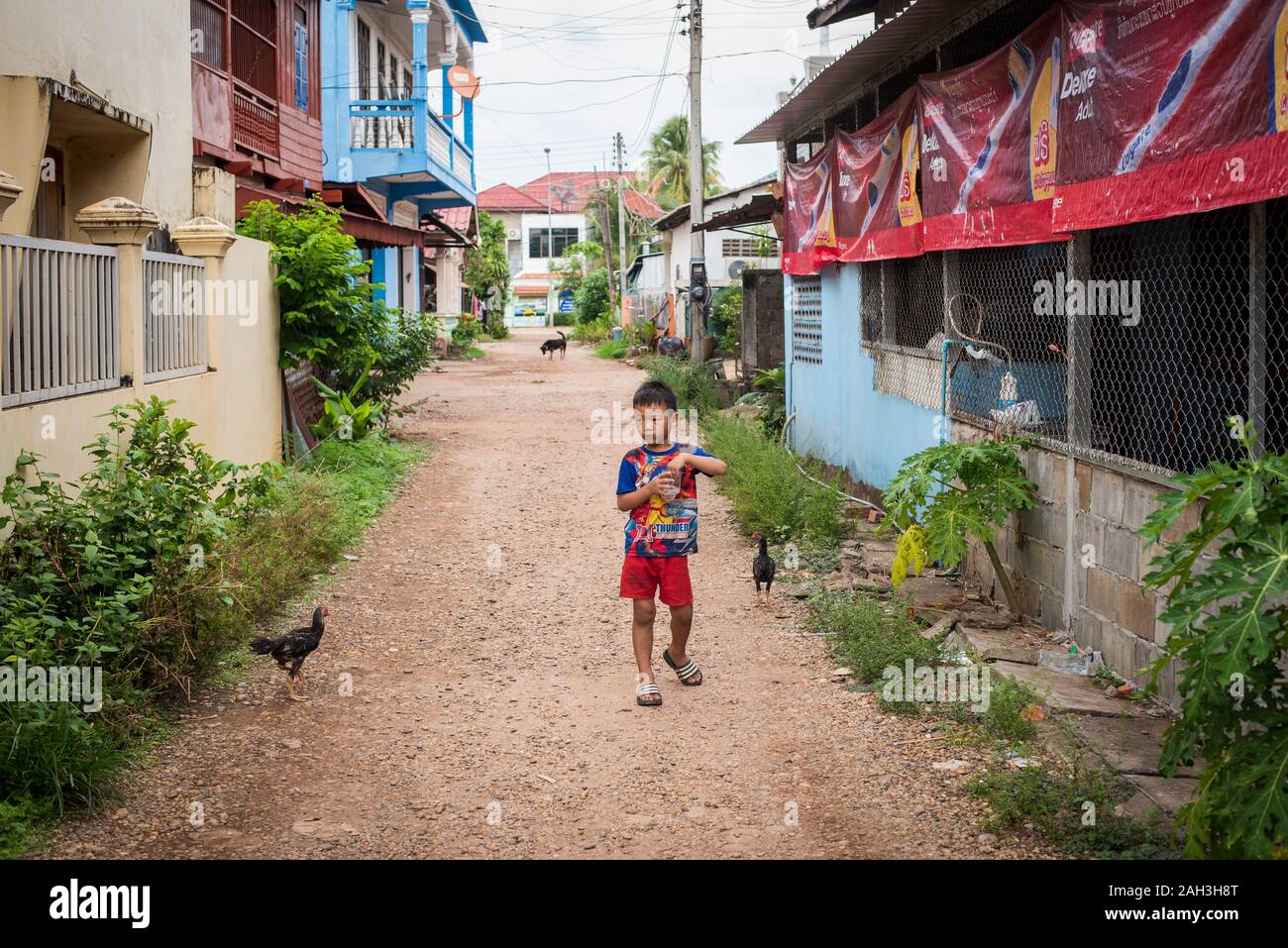 Boy walking on street in Paske, Laos Stock Photo