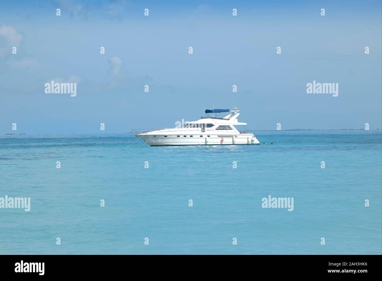 Super luxury motor yacht stopped in front of a white Caribbean beach. White beach and crystal clear turquoise sea. Isla Mujeres Mexico. Stock Photo