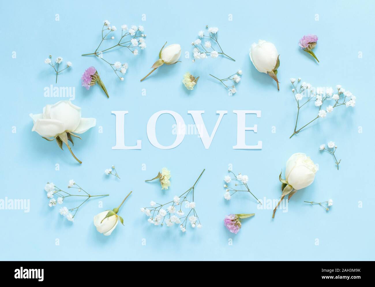 Flowers and word LOVE on a light blue background top view Stock Photo