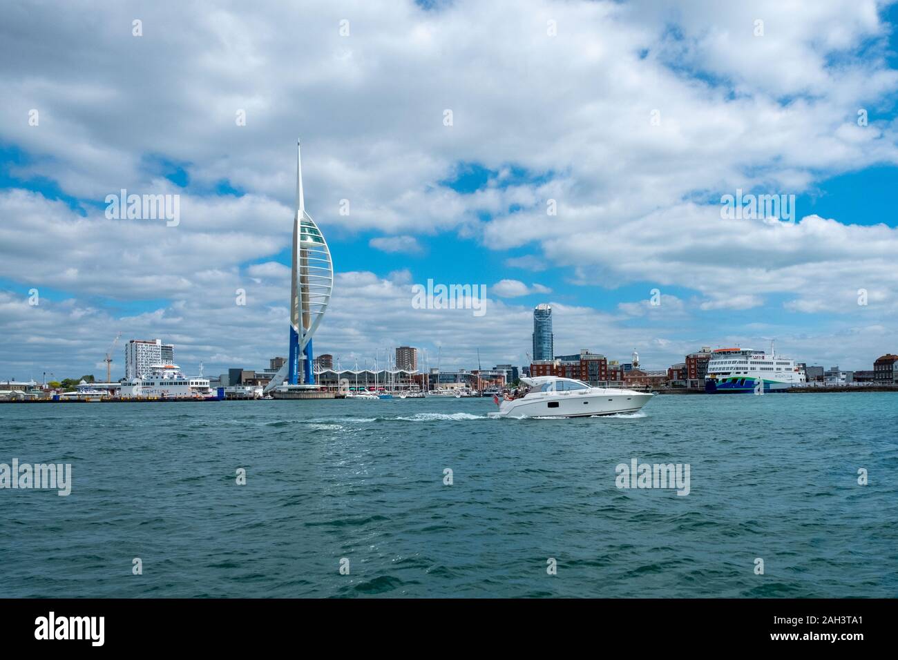 A power boat moves past the  Emirates Spinnaker Tower overlooking Portsmouth Harbour. The tower is 170m tall and has a viewing deck Stock Photo