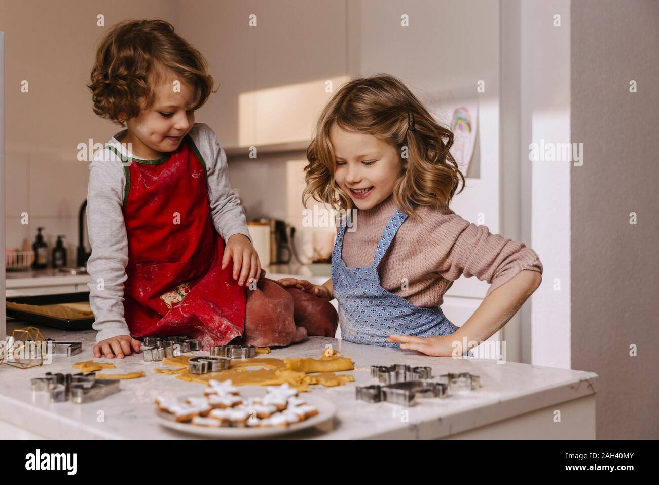 Two happy girls preparing Christmas cookies in kitchen Stock Photo