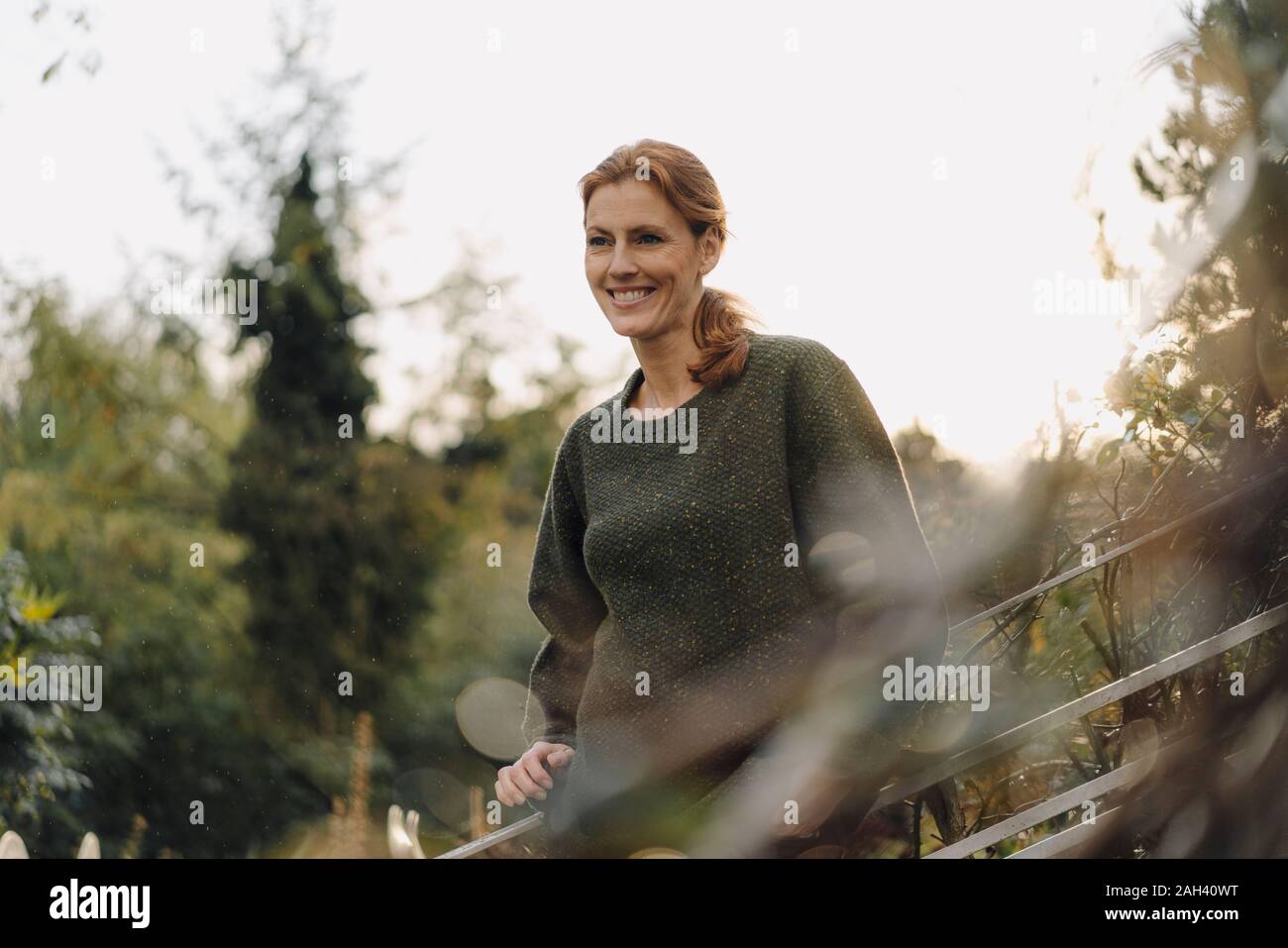 Smiling woman looking into her garden Stock Photo