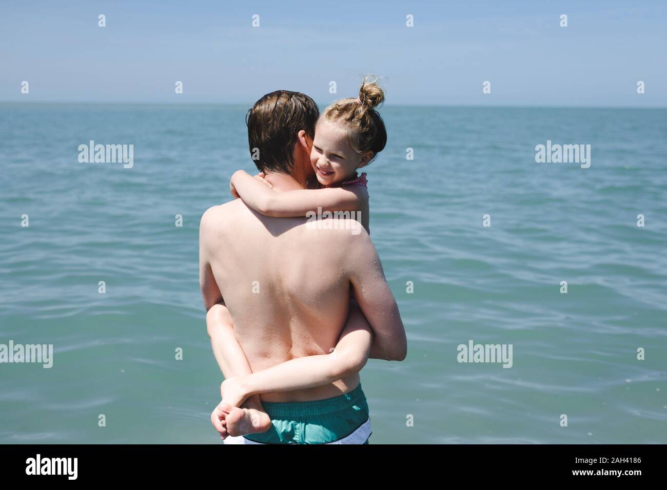 Father carrying his little daughter at the sea Stock Photo