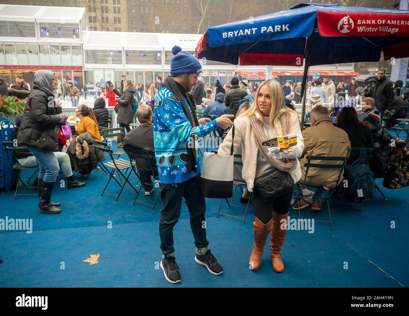 A brand ambassador in his ugly sweater from Nabisco’s Oreo cookies distributes free Oreo cookies outside the Oreo Holiday House brand activation in Bryant Park in New York on Saturday, December 14, 2019.  (© Richard B. Levine) Stock Photo
