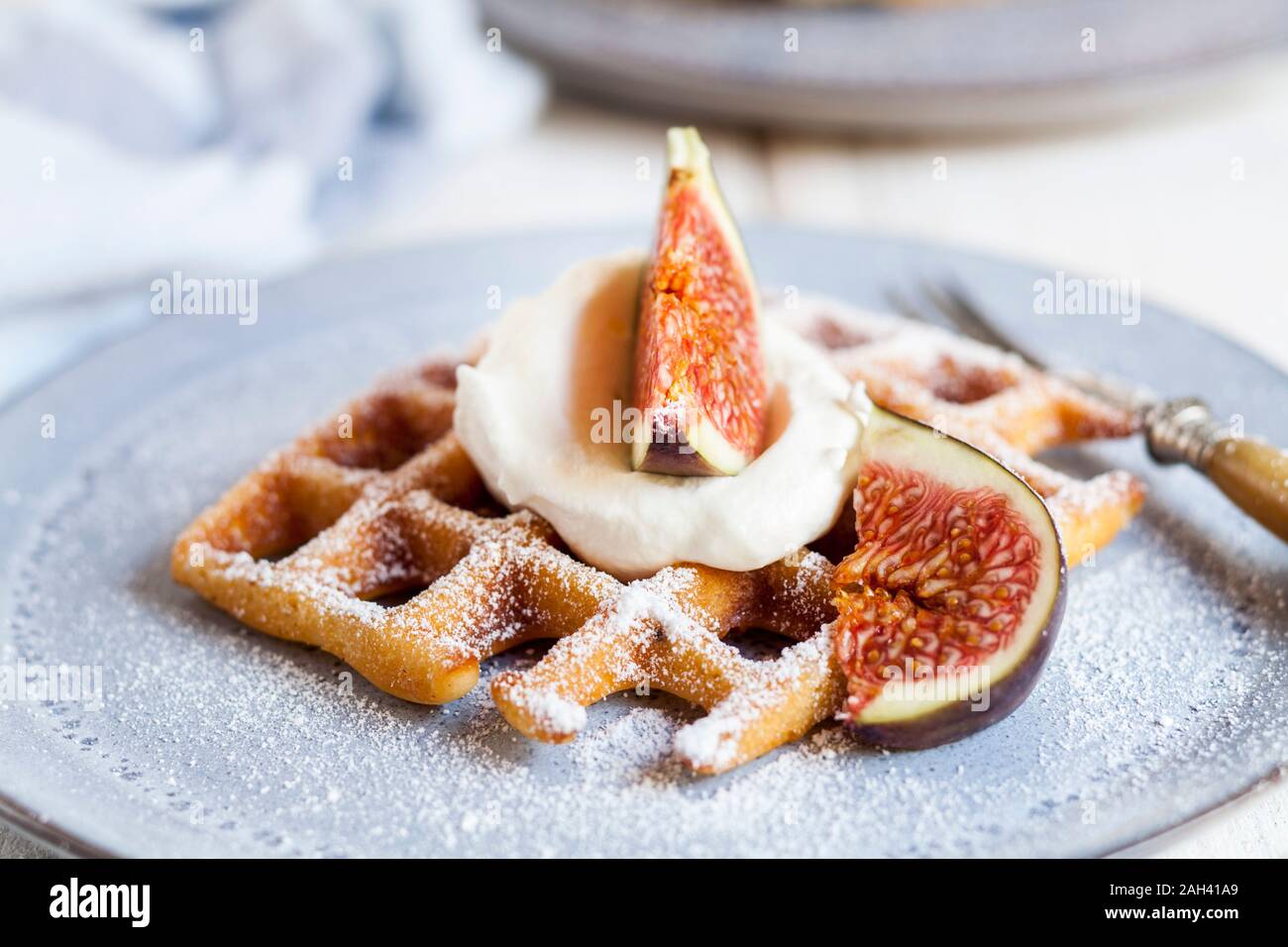 Thick Belgian waffle with whipped cream, powdered sugar and figs Stock Photo