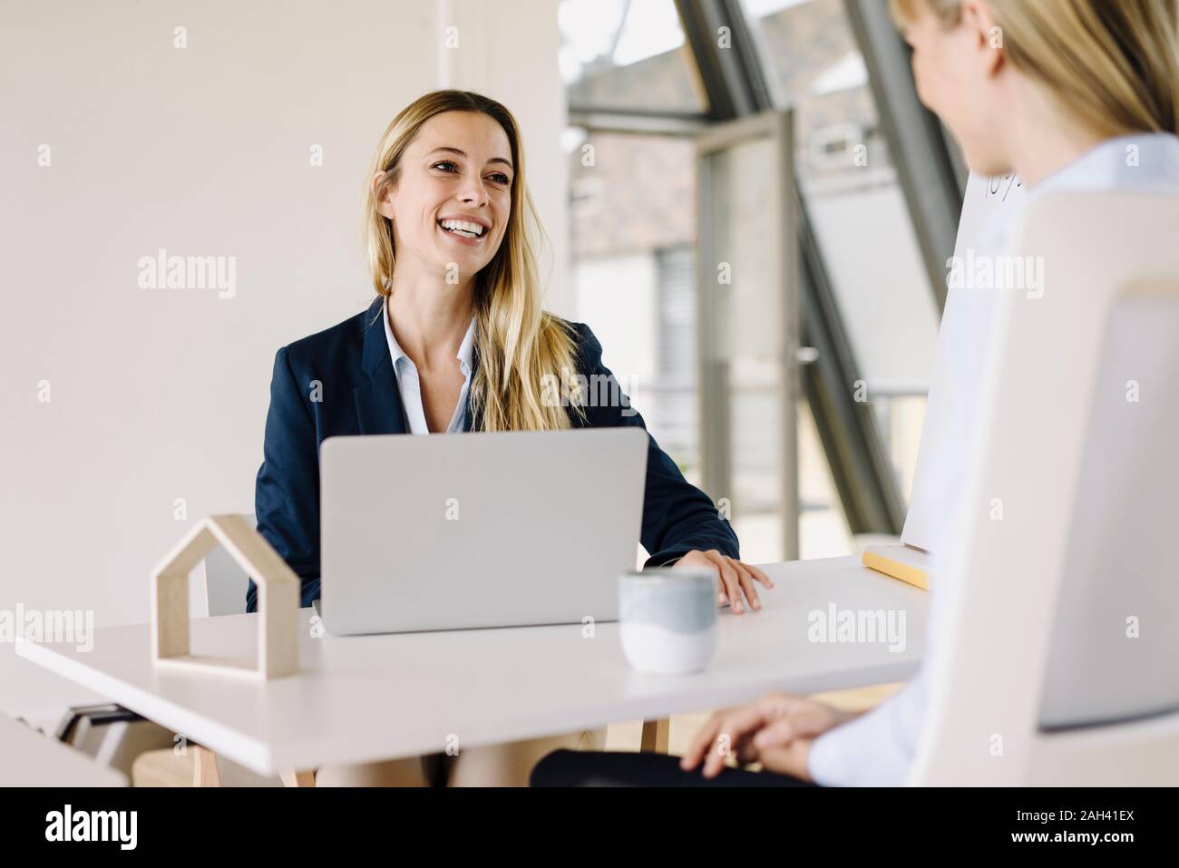 Two happy young businesswomen talking in office Stock Photo