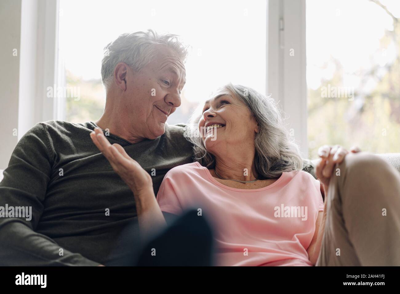 Happy senior couple relaxing on couch at home Stock Photo