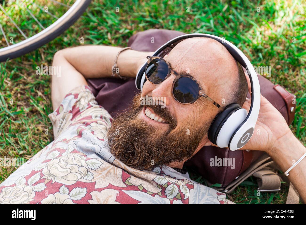 Mature man with red basecap, sunglasses and white headphones Stock Photo