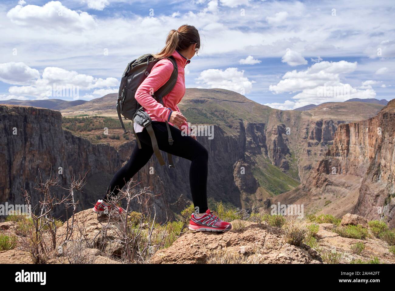 Woman hiking on top of a hill at Maletsunyane Falls, Lesotho Stock Photo