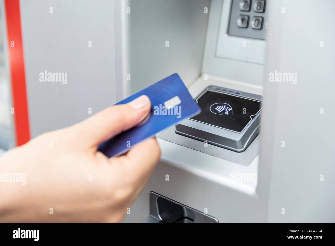 Close up of hand holding credit card and making contactless payment Stock Photo