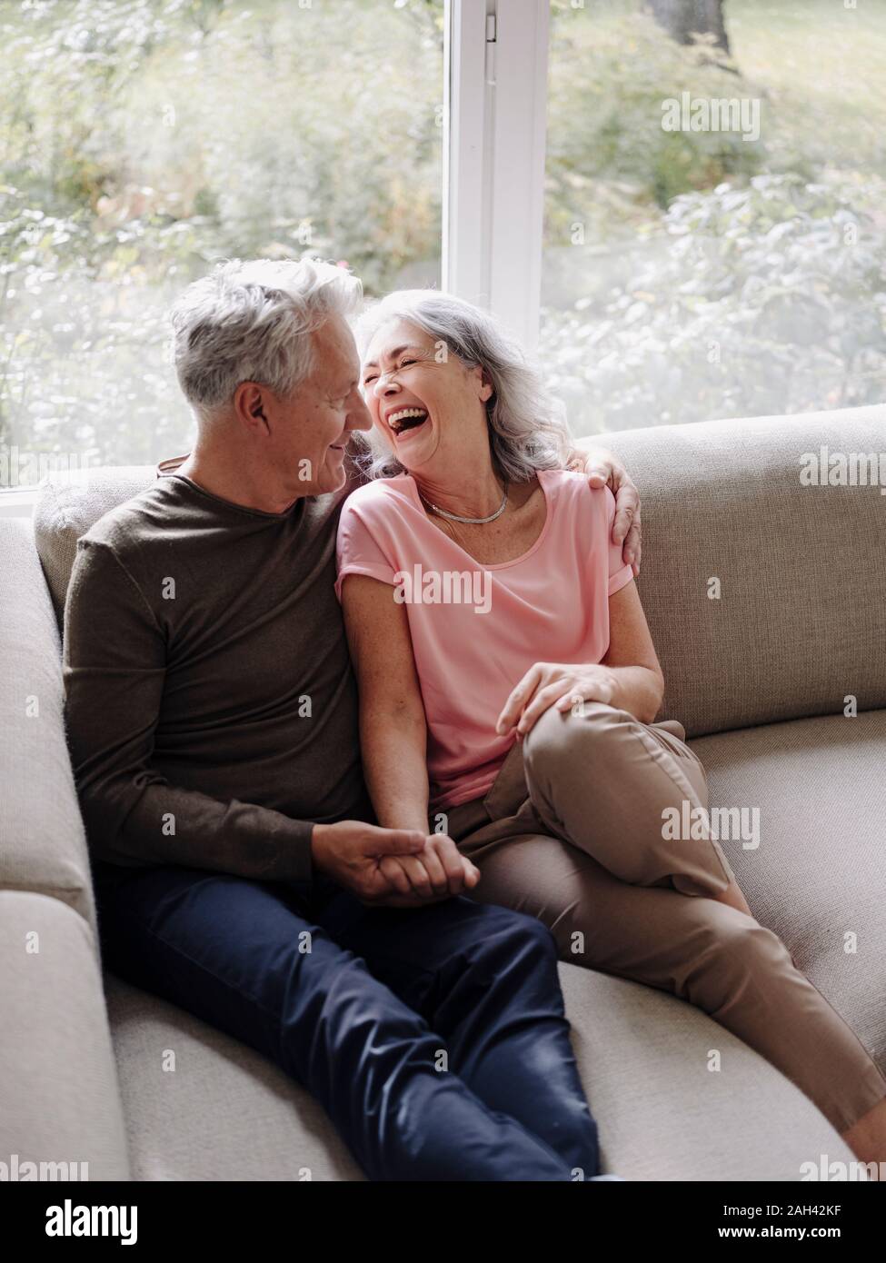 Happy senior couple relaxing on couch at home Stock Photo